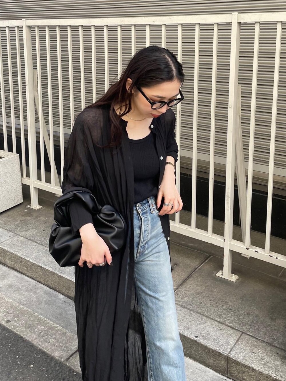 ブラック系のパンプス、ブルー系のデニムパンツ、ブラック系のタンクトップを着用したレディースの春コーディネートの5枚目の写真