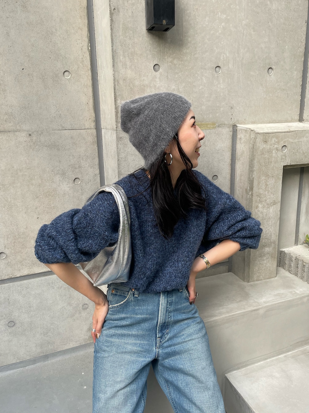 ブルー系のニット/セーター、ブルー系のデニムパンツ、ブラック系のスニーカーを着用したレディースの秋コーディネートの4枚目の写真