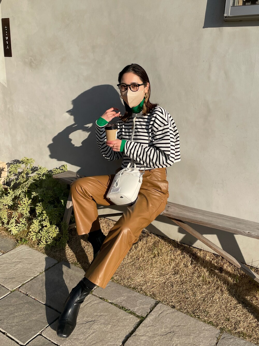 ブラック系のTシャツ/カットソー、ブラウン系のその他パンツ、ホワイト系のショルダーバッグを着用したレディースの冬コーディネートの2枚目の写真