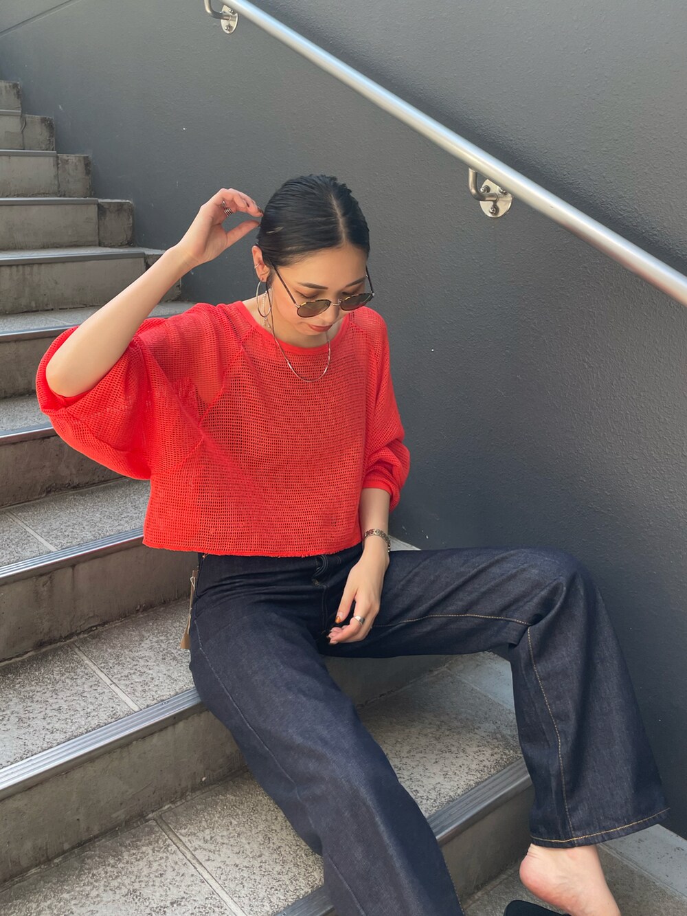 ブラック系のサンダル、ブルー系のデニムパンツ、レッド系のTシャツ/カットソーを着用したレディースの夏コーディネートの5枚目の写真