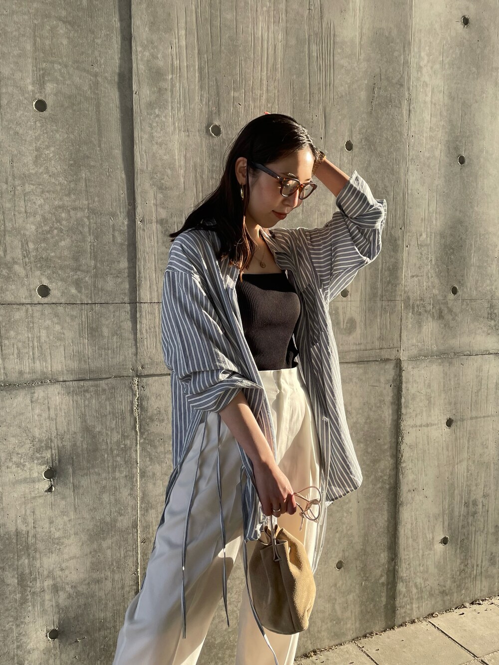 ブラック系のキャミソール、ブルー系のシャツ/ブラウス、ベージュ系のハンドバッグを着用したレディースの春コーディネートの4枚目の写真