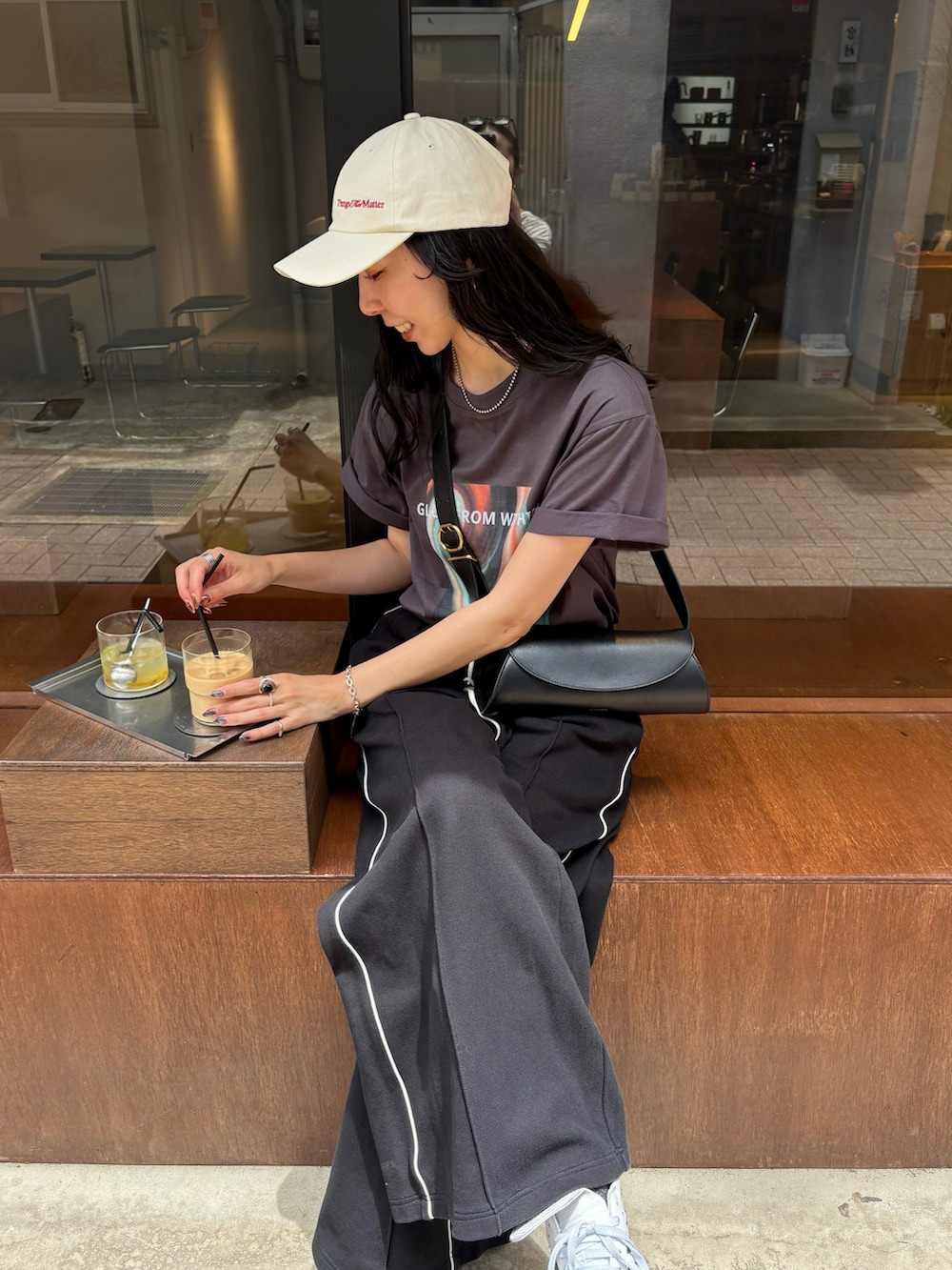 ホワイト系のスニーカー、ブラック系のショルダーバッグ、ブラック系のその他パンツを着用したレディースの夏コーディネートの4枚目の写真