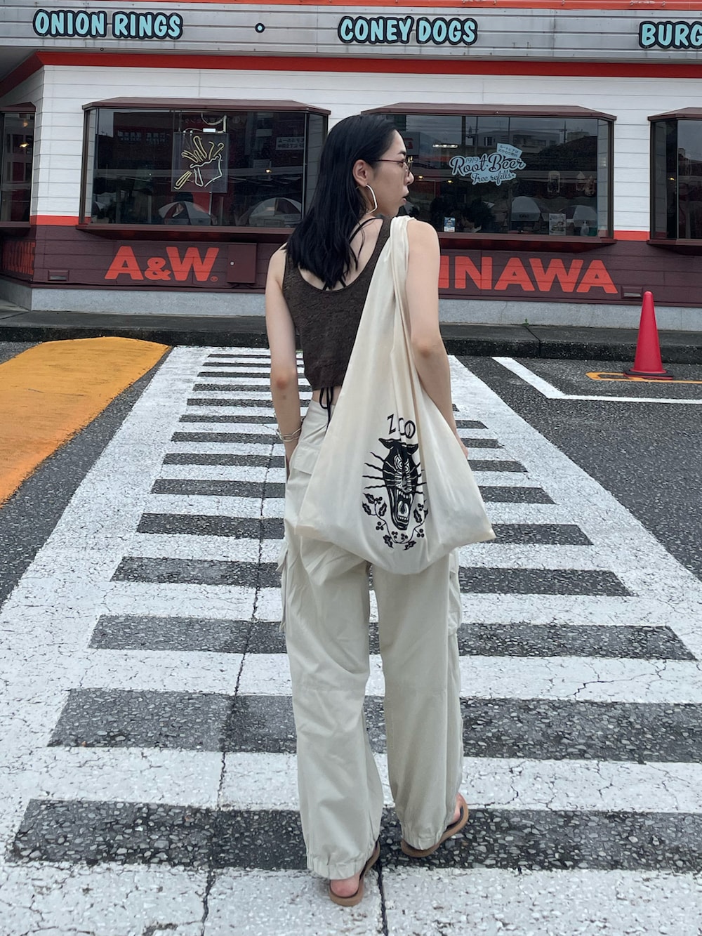 ホワイト系のカーゴパンツ、ブラック系のサンダル、ブラック系のショルダーバッグを着用したレディースの秋コーディネートの4枚目の写真