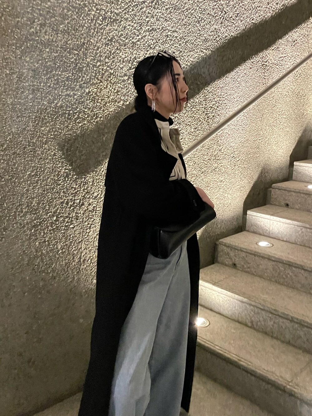 ブラック系のチェスターコート、ホワイト系のシャツ/ブラウス、ゴールド系のパンプスを着用したレディースの春コーディネートの5枚目の写真