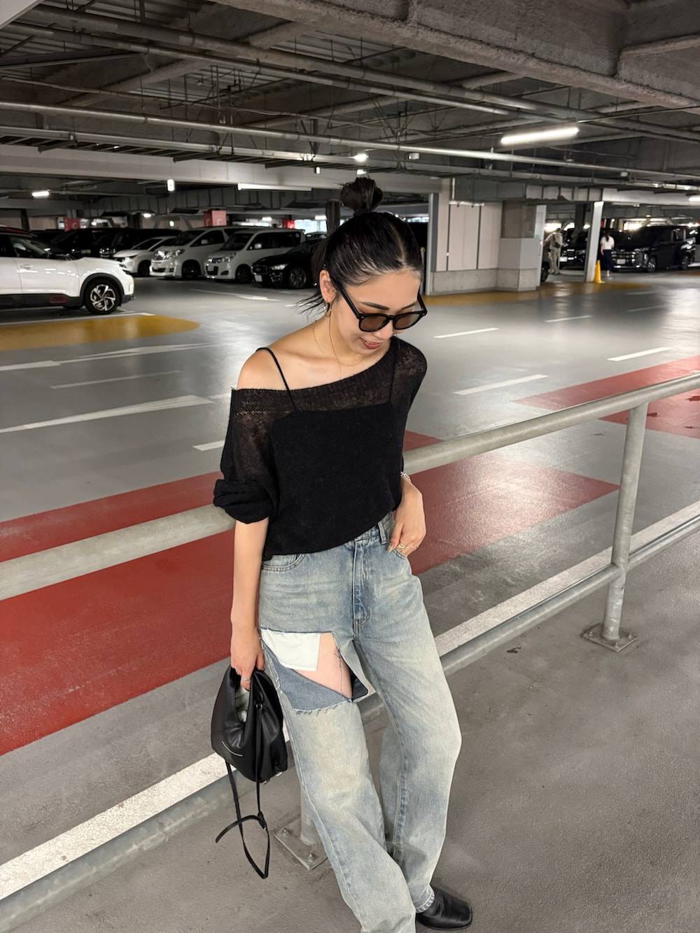 ブラック系のショルダーバッグ、ブラック系のブーツを着用したレディースの夏コーディネートの3枚目の写真