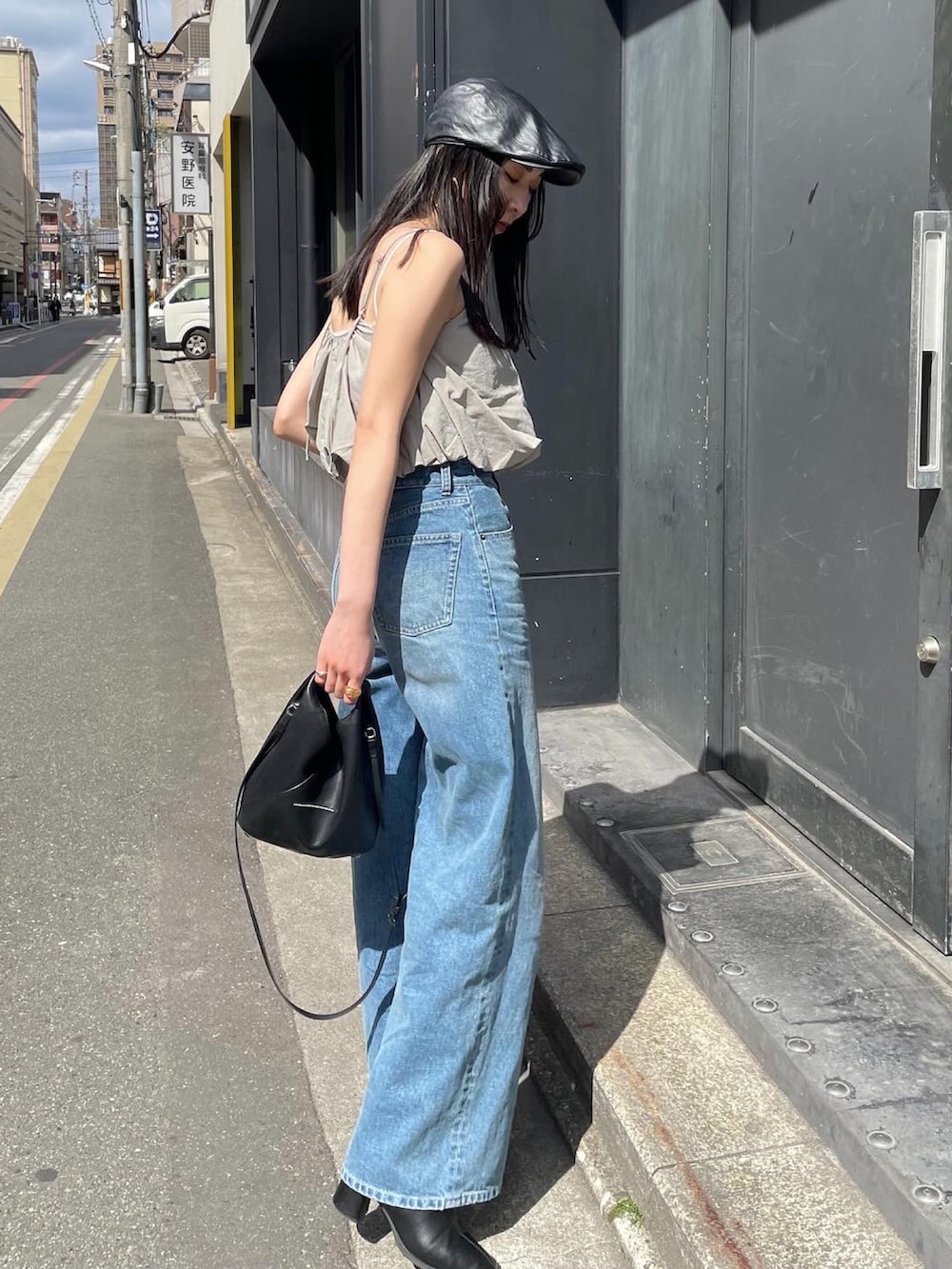 ブラック系のショルダーバッグ、ブラック系のブーツ、ブラック系のハンチング/ベレー帽を着用したレディースの春コーディネートの3枚目の写真