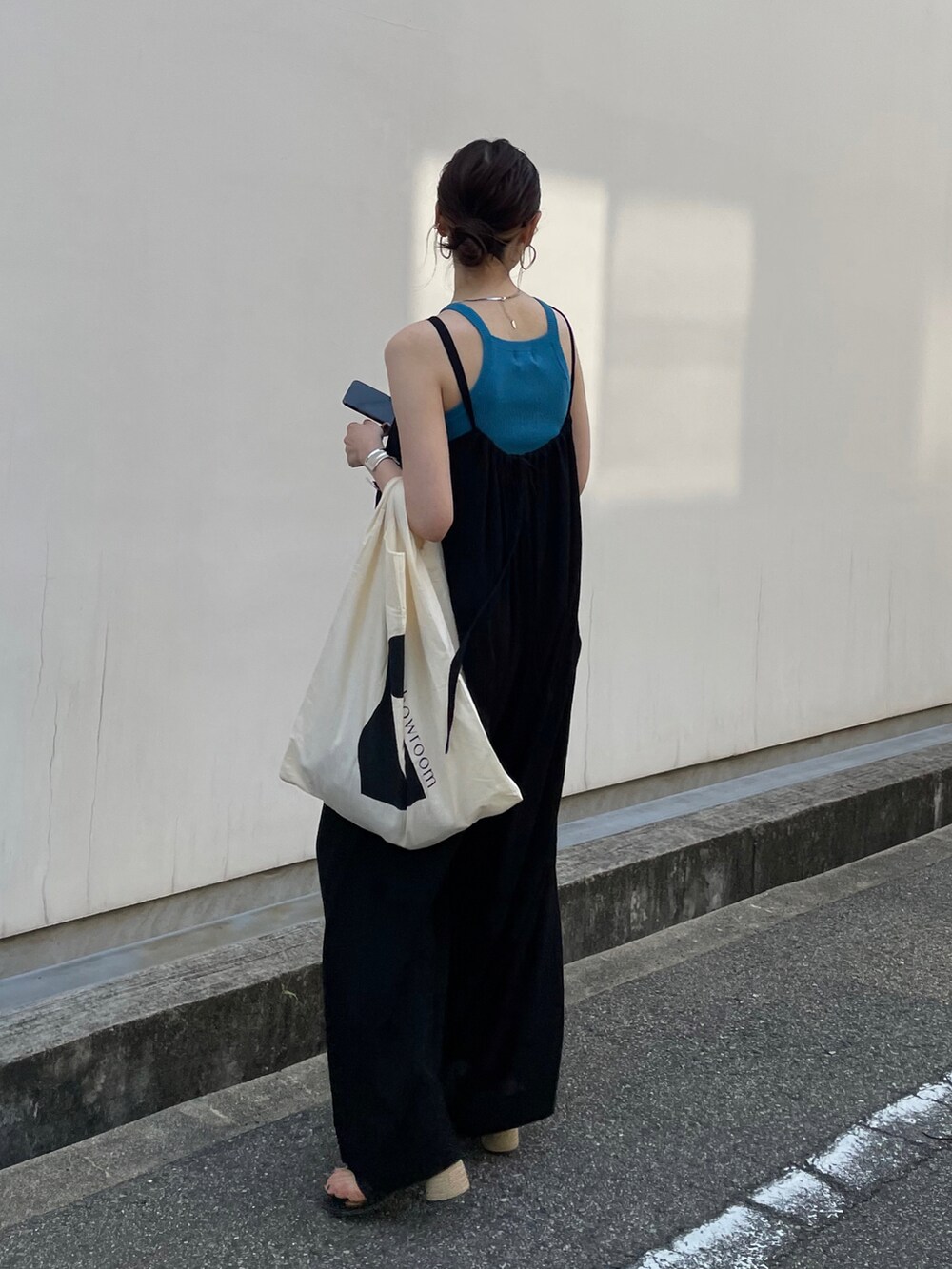 ブラック系のオールインワン・サロペット、ブルー系のタンクトップ、ブラック系のサンダルを着用したレディースの春コーディネートの3枚目の写真