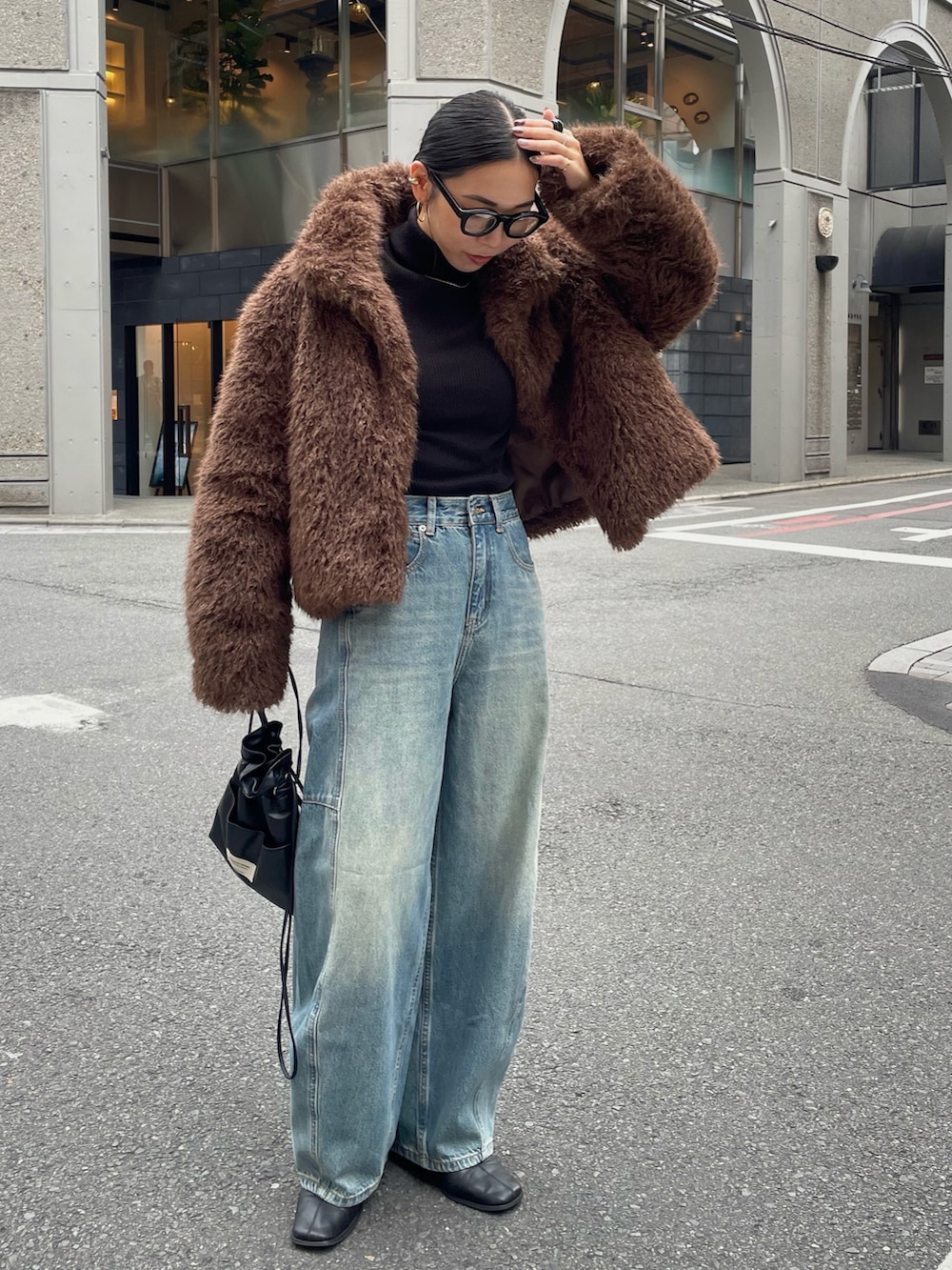 ブラック系のブーツ、ブラック系のショルダーバッグを着用したレディースの秋コーディネートの2枚目の写真