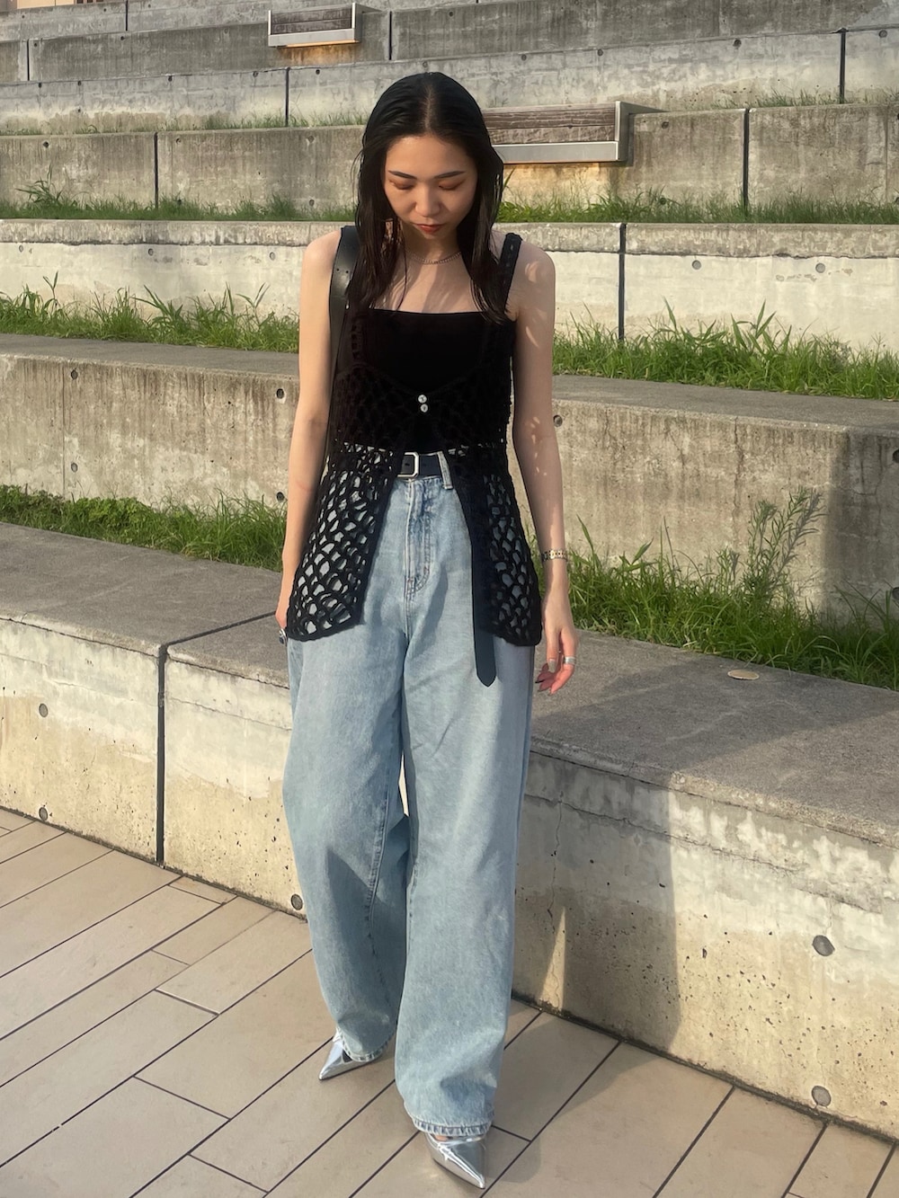 ブルー系のデニムパンツ、ブラック系のショルダーバッグ、ブラック系のキャミソールを着用したレディースの夏コーディネートの3枚目の写真