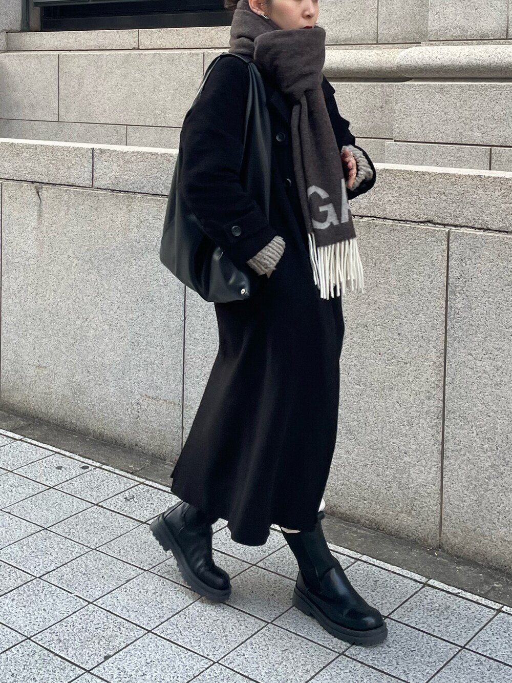 ブラック系のブーツ、ブラック系のハンドバッグ、ホワイト系のスウェットパンツを着用したレディースの冬コーディネートの2枚目の写真