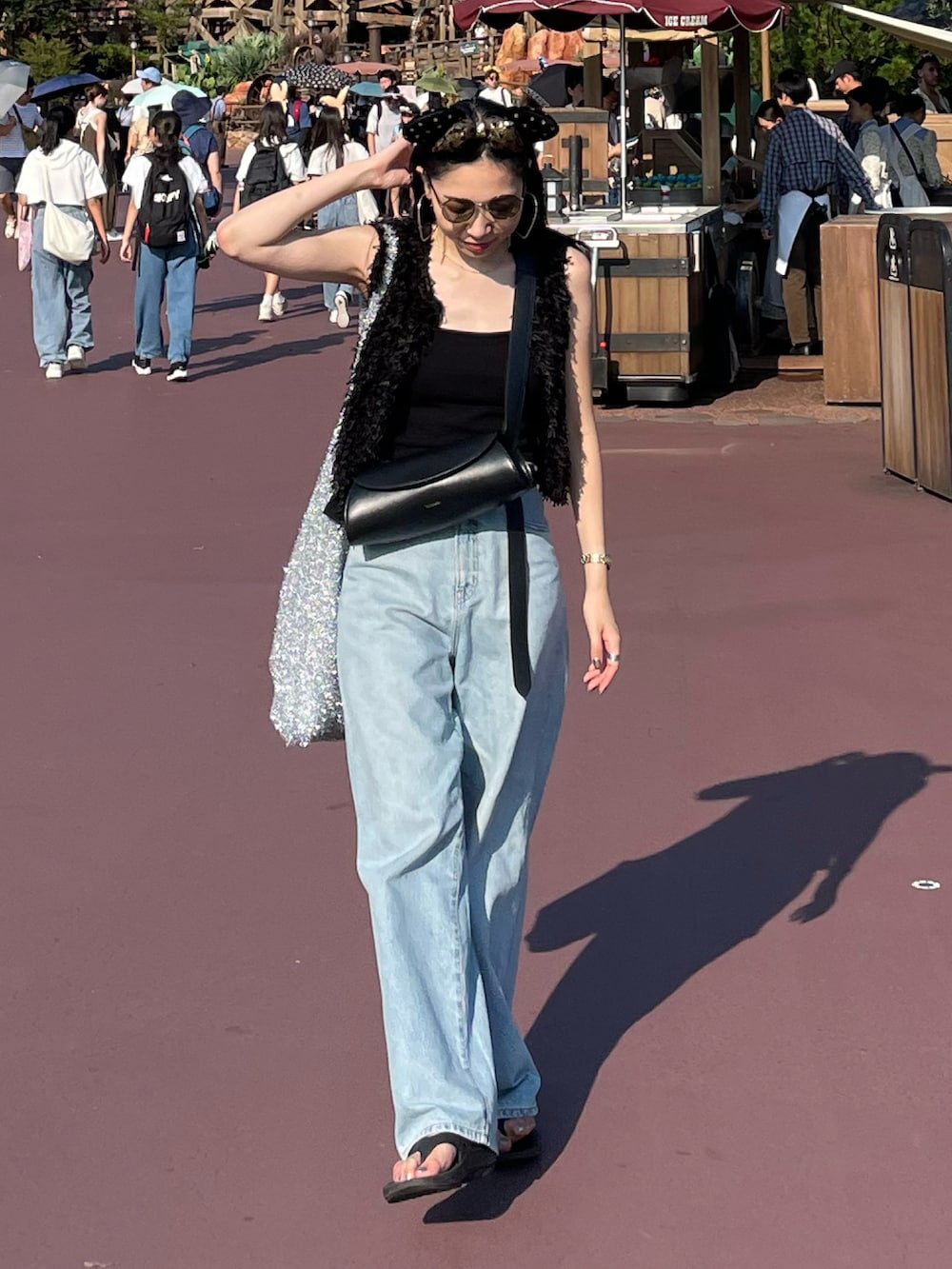 ブルー系のデニムパンツ、ブラック系のサンダル、ブラック系のキャミソールを着用したレディースの夏コーディネートの4枚目の写真