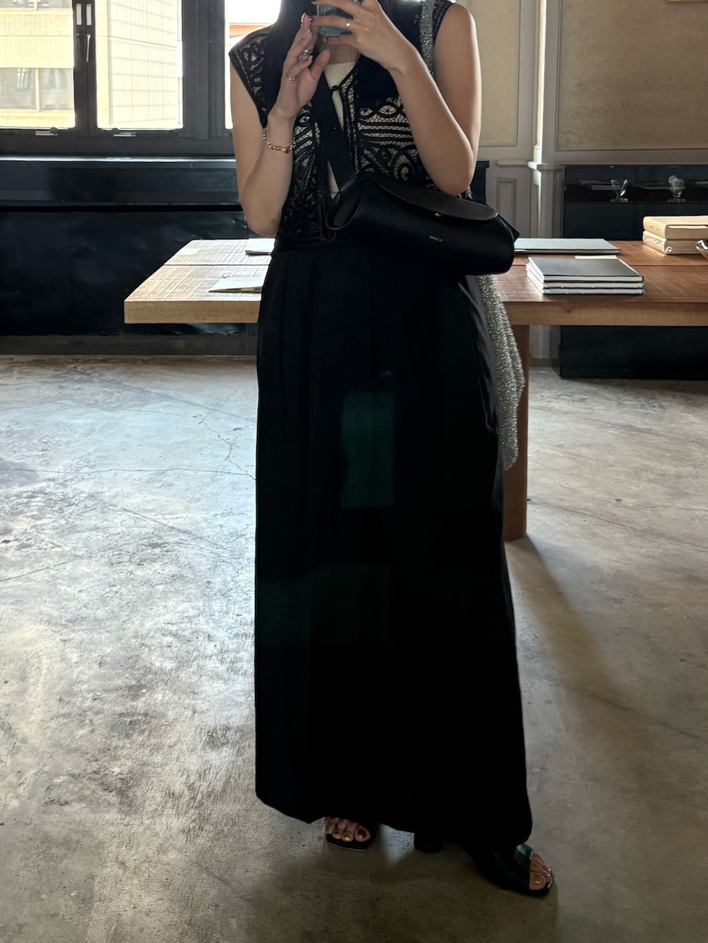 ブラック系のサンダル、ブラック系のスラックス、ブラック系のベストを着用したレディースの夏コーディネートの5枚目の写真