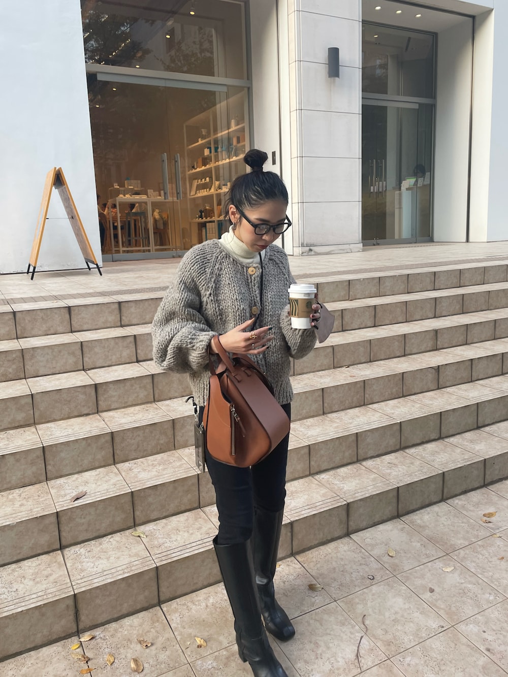 ブラウン系のバックパック/リュック、ブラック系のデニムパンツ、ブラック系のブーツを着用したレディースの秋コーディネートの5枚目の写真