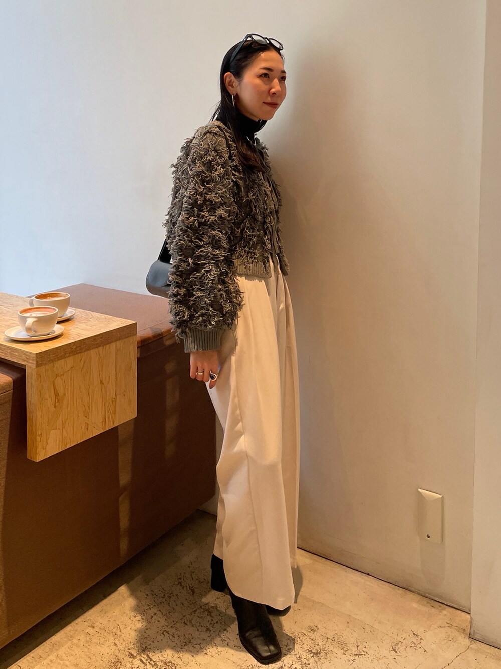 ホワイト系のその他パンツ、ブラック系のブーツ、グレー系のニット/セーターを着用したレディースの秋コーディネートの4枚目の写真