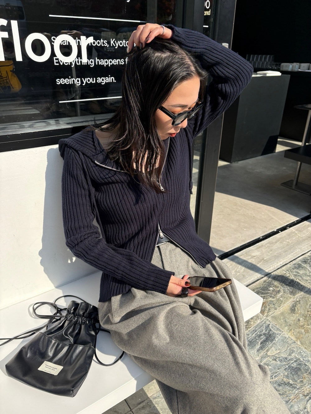 ブラック系のショルダーバッグ、ブラック系のブーツを着用したレディースの秋コーディネートの3枚目の写真