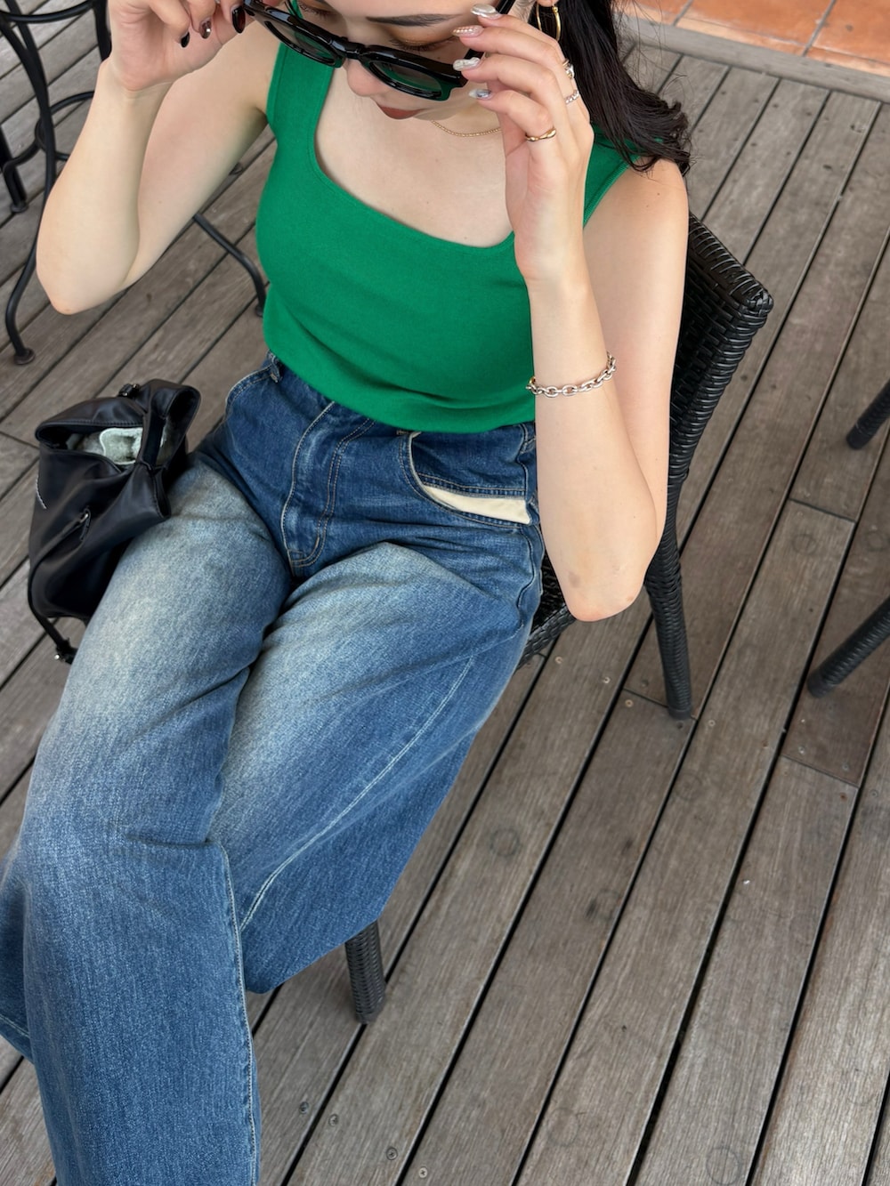 ブラック系のブーツ、ブラック系のショルダーバッグを着用したレディースの夏コーディネートの3枚目の写真