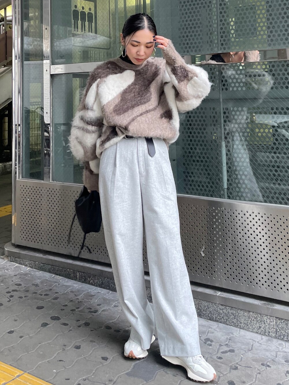 ブラック系のショルダーバッグ、グレー系のその他パンツ、ホワイト系のスニーカーを着用したレディースの冬コーディネートの3枚目の写真