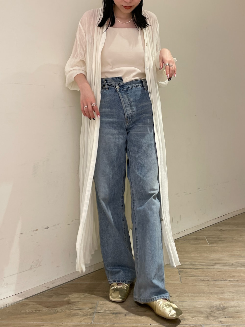 ブルー系のデニムパンツ、ホワイト系のキャミソール、ホワイト系のワンピースを着用したレディースの春コーディネートの2枚目の写真