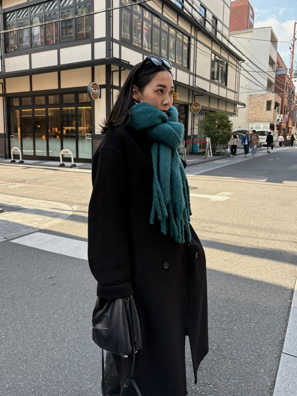 ブラック系のブーツ、ブラック系のショルダーバッグを着用したレディースの秋コーディネートの4枚目の写真