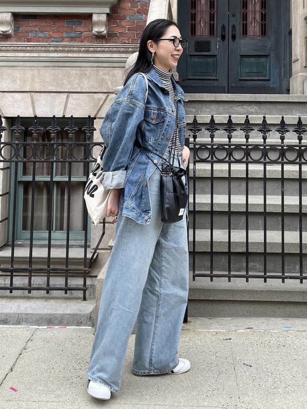 ブラック系のショルダーバッグ、ホワイト系のトートバッグ、ブルー系のデニムジャケットを着用したレディースの冬コーディネートの4枚目の写真