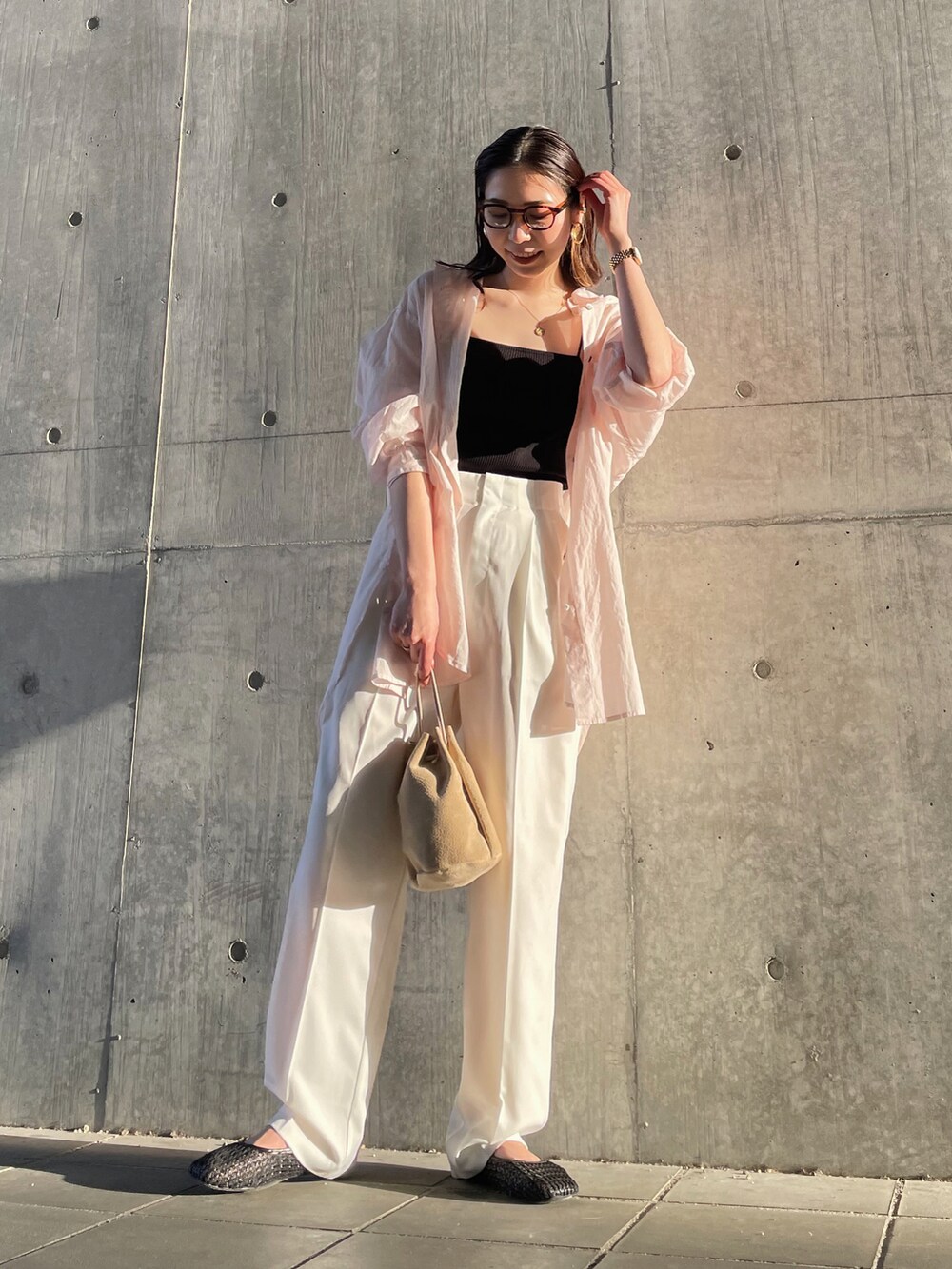 ブラック系のキャミソール、ホワイト系のスラックス、ピンク系のシャツ/ブラウスを着用したレディースの春コーディネートの2枚目の写真