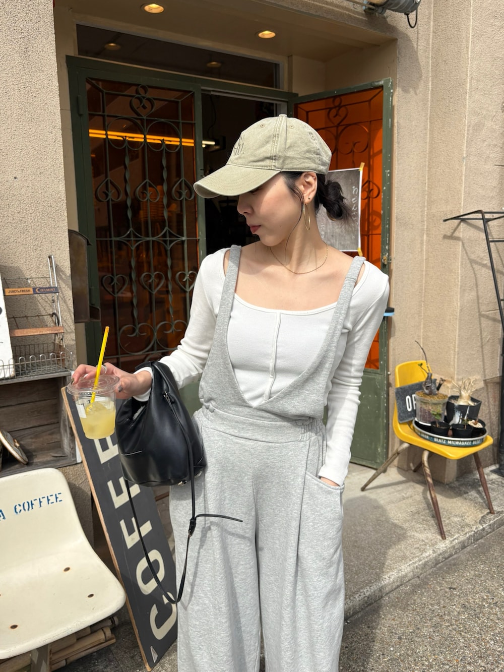 ブラック系のショルダーバッグ、ブラック系のサンダル、シルバー系のネックレスを着用したレディースの春コーディネートの4枚目の写真