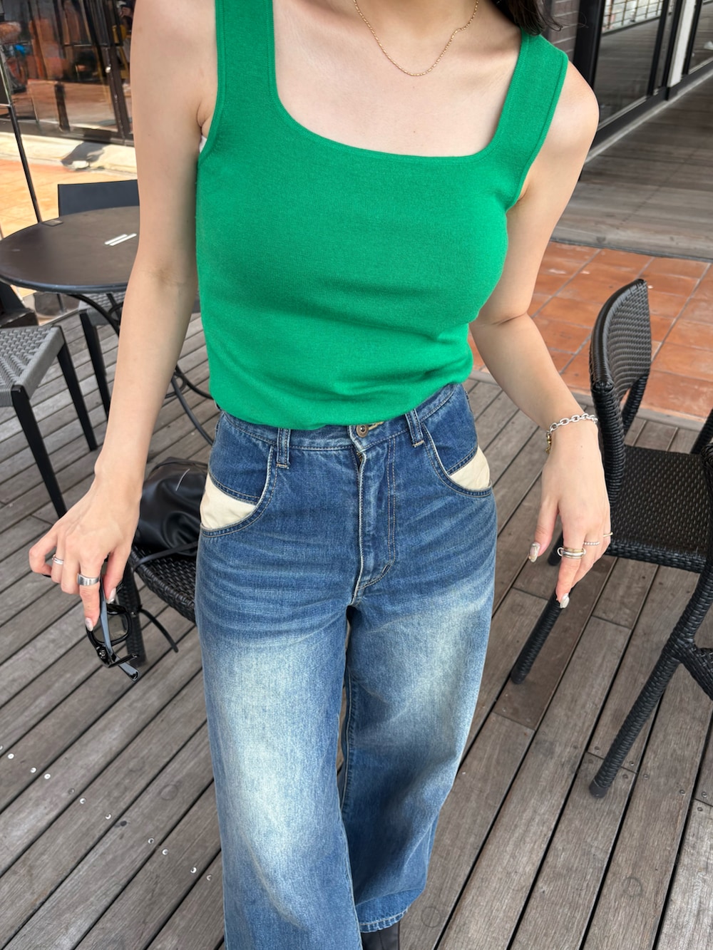 ブラック系のブーツ、ブラック系のショルダーバッグを着用したレディースの夏コーディネートの5枚目の写真