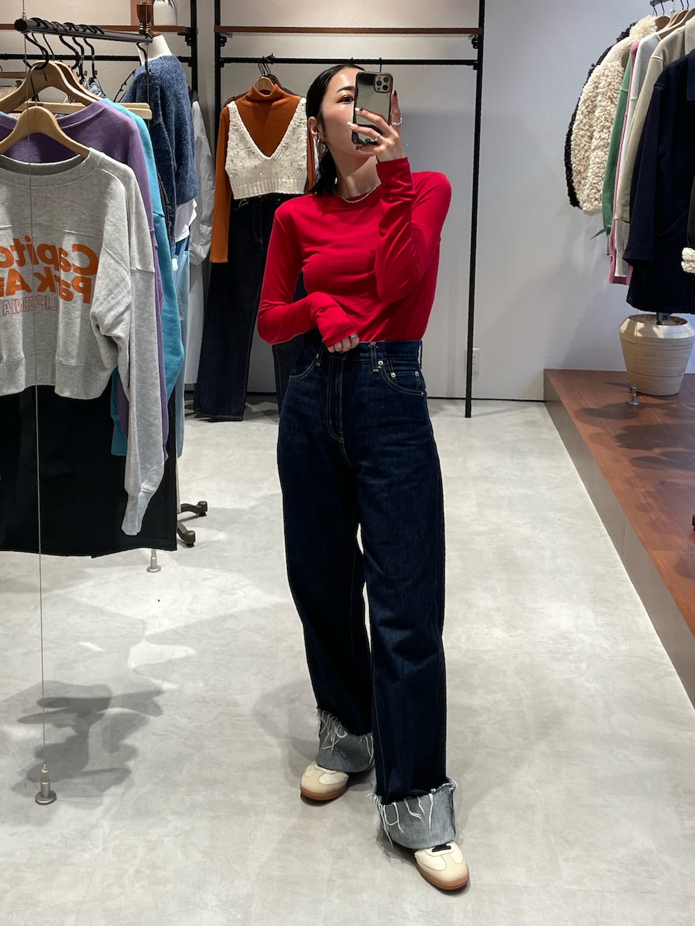 ブルー系のデニムパンツ、ベージュ系のスニーカー、ブルー系のデニムジャケットを着用したレディースの秋コーディネートの3枚目の写真