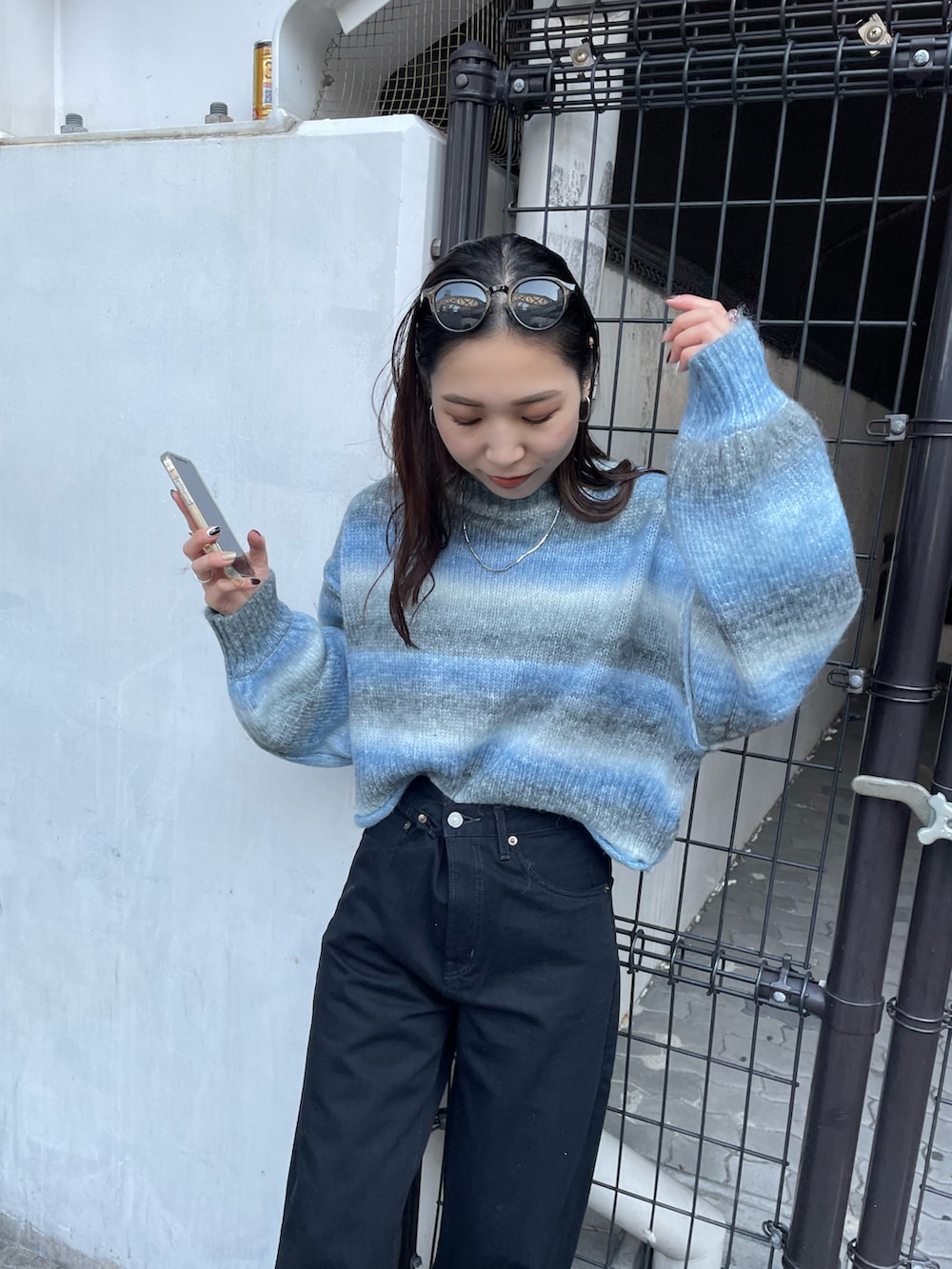 ブラック系のデニムパンツ、ブルー系のニット/セーターを着用したレディースの秋コーディネートの5枚目の写真