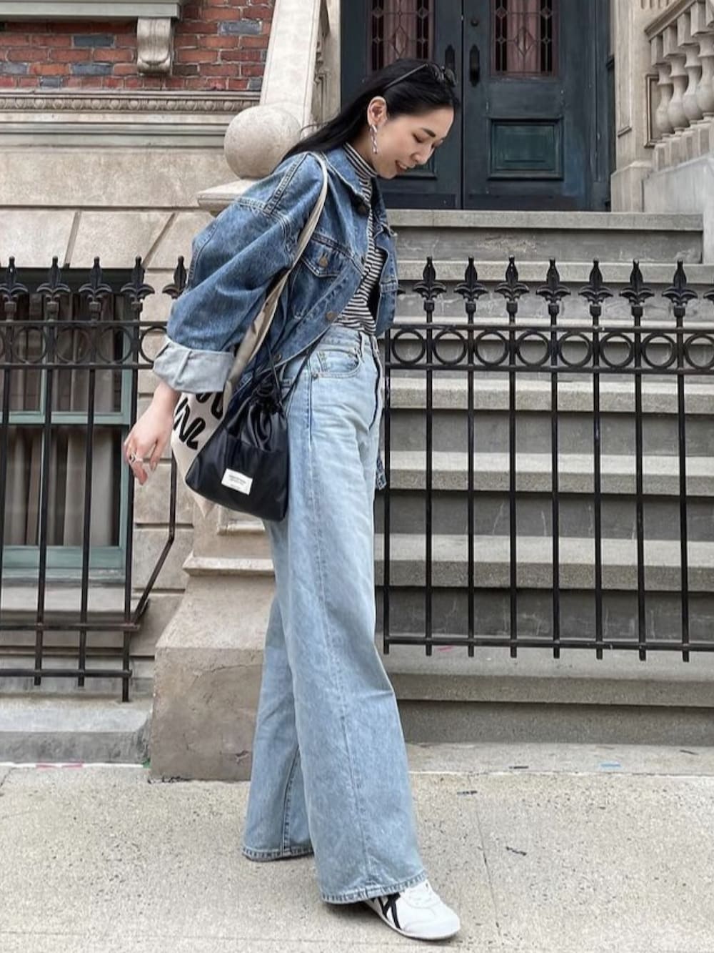 ブラック系のショルダーバッグ、ホワイト系のトートバッグ、ブルー系のデニムジャケットを着用したレディースの冬コーディネートの2枚目の写真