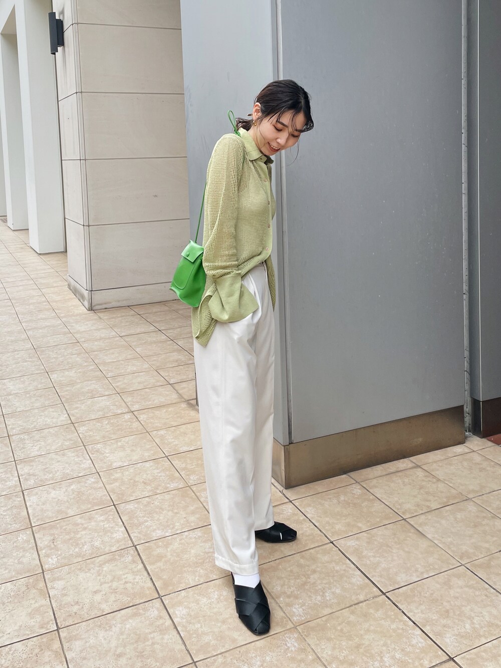 グリーン系のニット/セーター、ホワイト系のキャミソール、ホワイト系のその他パンツを着用したレディースの春コーディネートの5枚目の写真