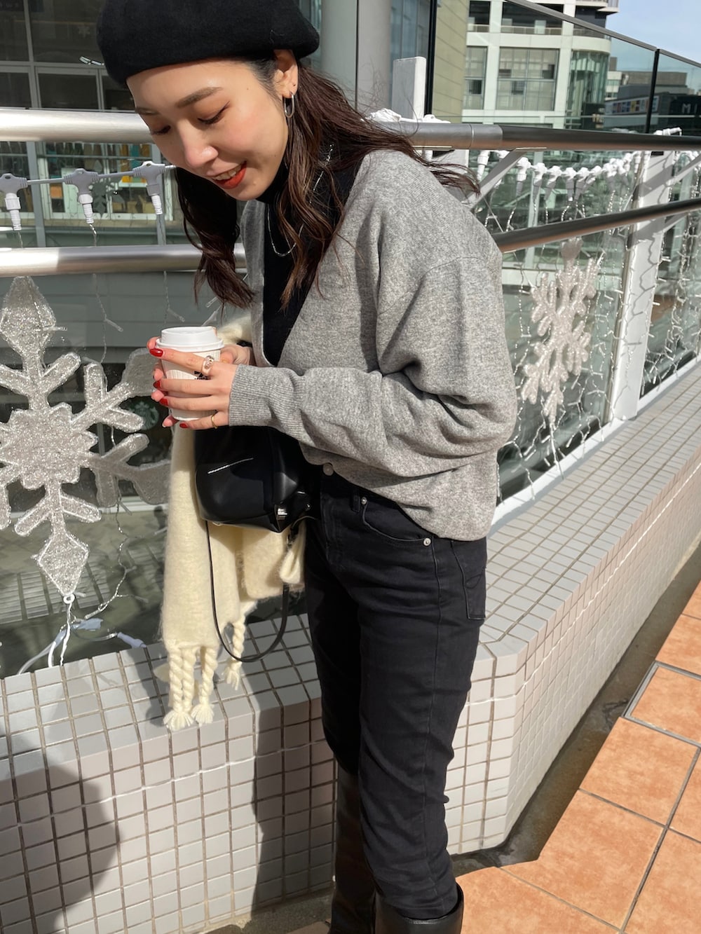 ブラック系のブーツ、ブラック系のデニムパンツ、ブラック系のショルダーバッグを着用したレディースの冬コーディネートの5枚目の写真