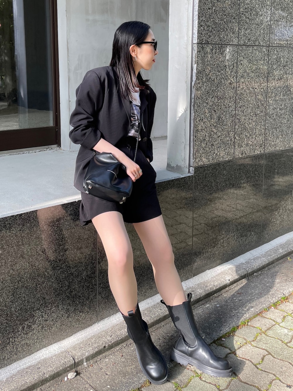 ブラック系のブーツ、ブラック系のショルダーバッグ、ホワイト系のTシャツ/カットソーを着用したレディースの春コーディネートの2枚目の写真