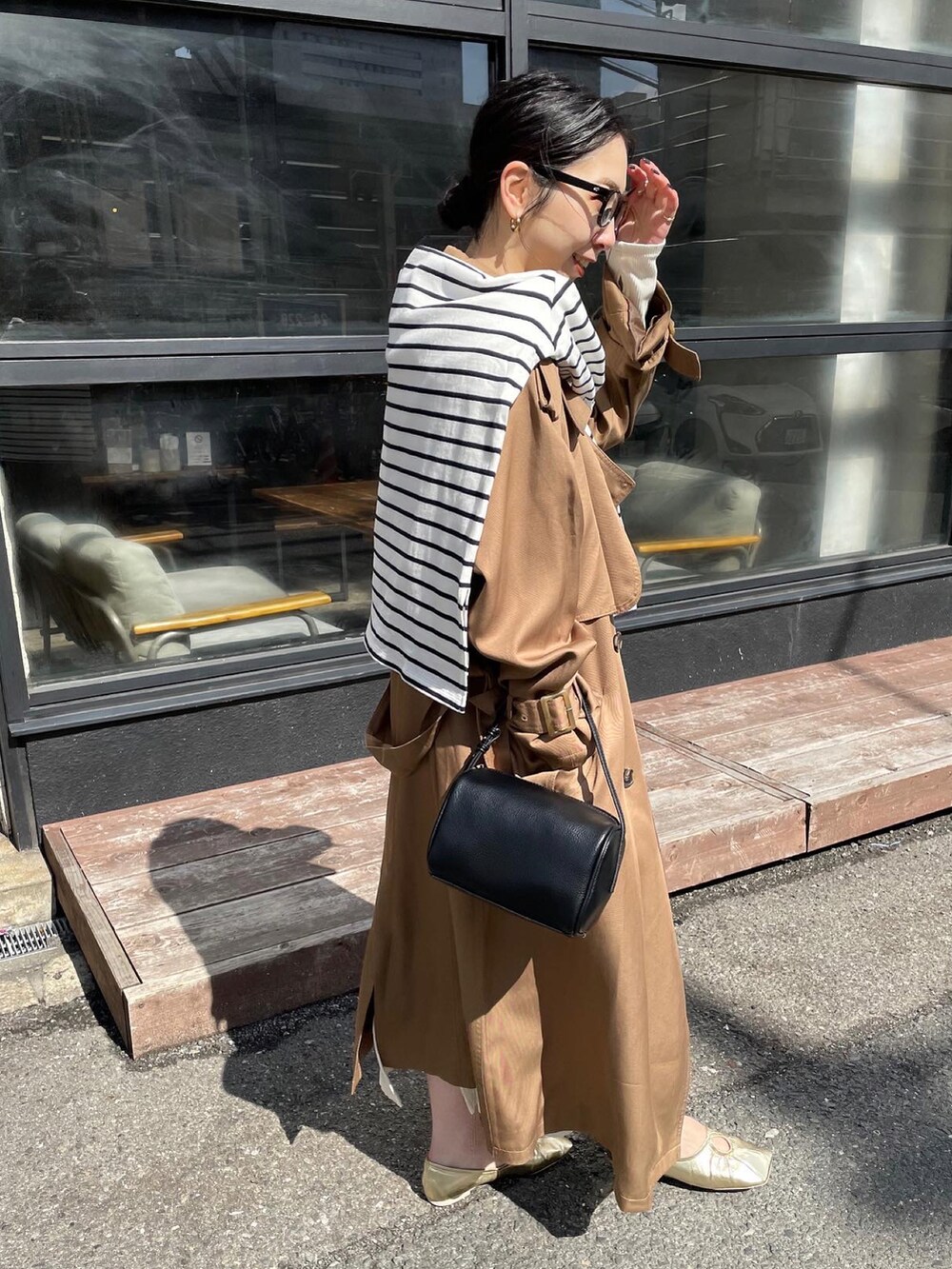 ゴールド系のパンプス、イエロー系のトレンチコート、ホワイト系のワンピースを着用したレディースの冬コーディネートの3枚目の写真