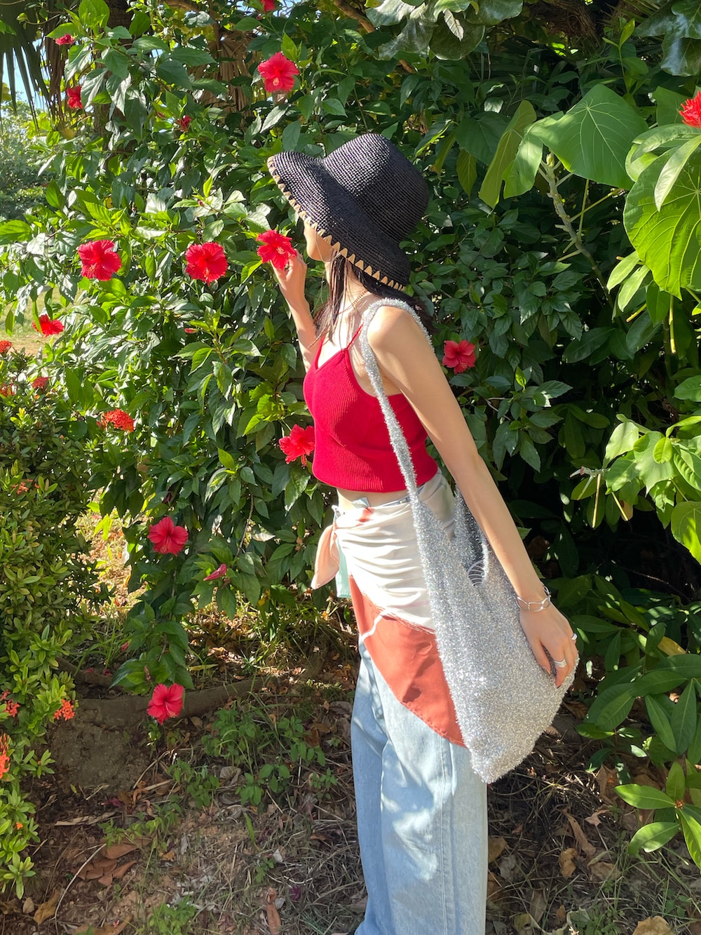 ブラック系のサンダル、ブルー系のデニムパンツ、ブラック系のショルダーバッグを着用したレディースの秋コーディネートの3枚目の写真