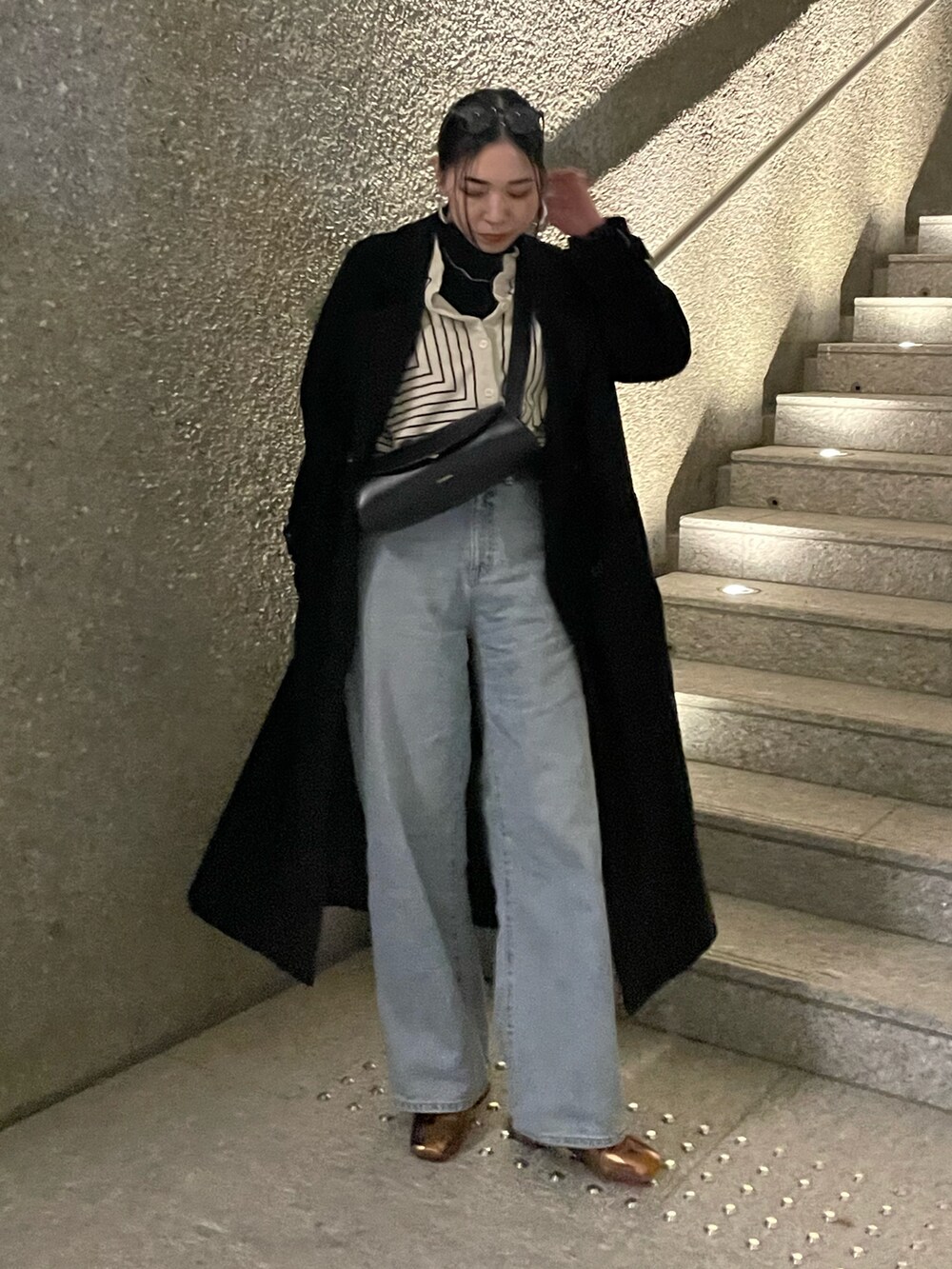 ブラック系のチェスターコート、ホワイト系のシャツ/ブラウス、ゴールド系のパンプスを着用したレディースの春コーディネートの4枚目の写真