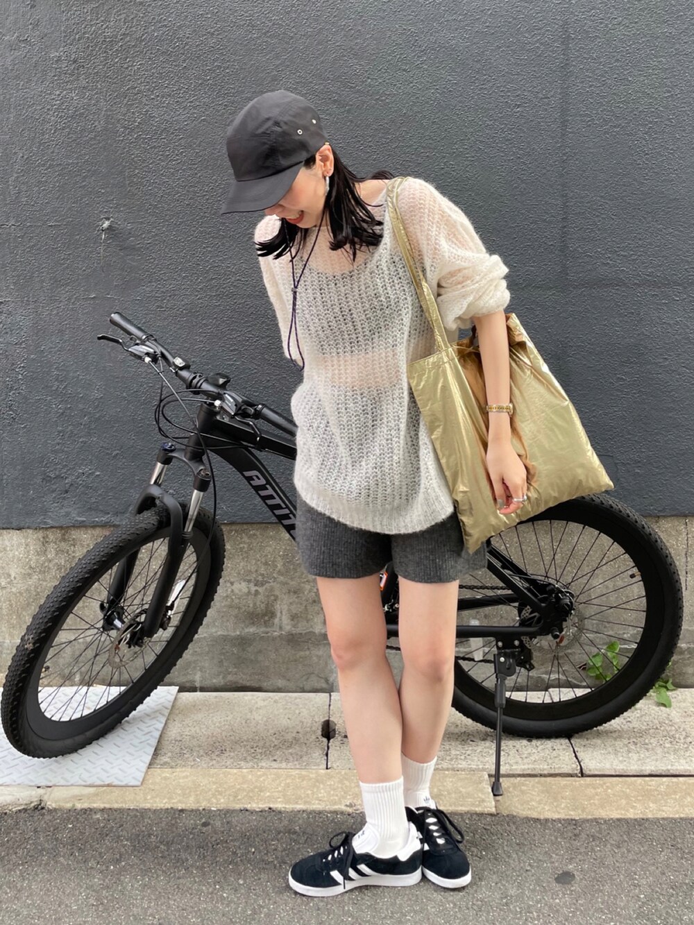 ブラック系のスニーカー、ホワイト系のニット/セーター、グレー系のその他パンツを着用したレディースの秋コーディネートの3枚目の写真