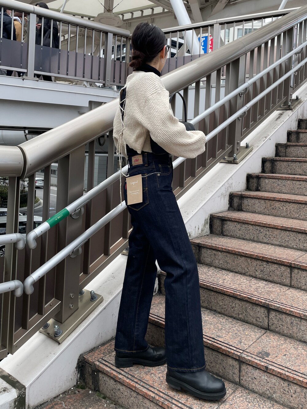 ブルー系のデニムパンツ、ブラック系のワンピースを着用したレディースの冬コーディネートの2枚目の写真