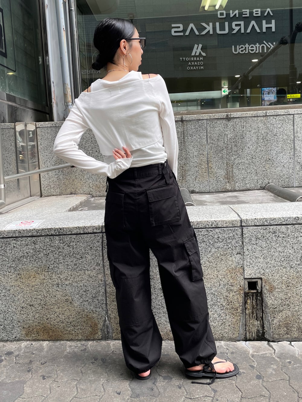 ブラック系のショルダーバッグ、ブラック系のサンダル、ホワイト系のTシャツ/カットソーを着用したレディースの夏コーディネートの3枚目の写真