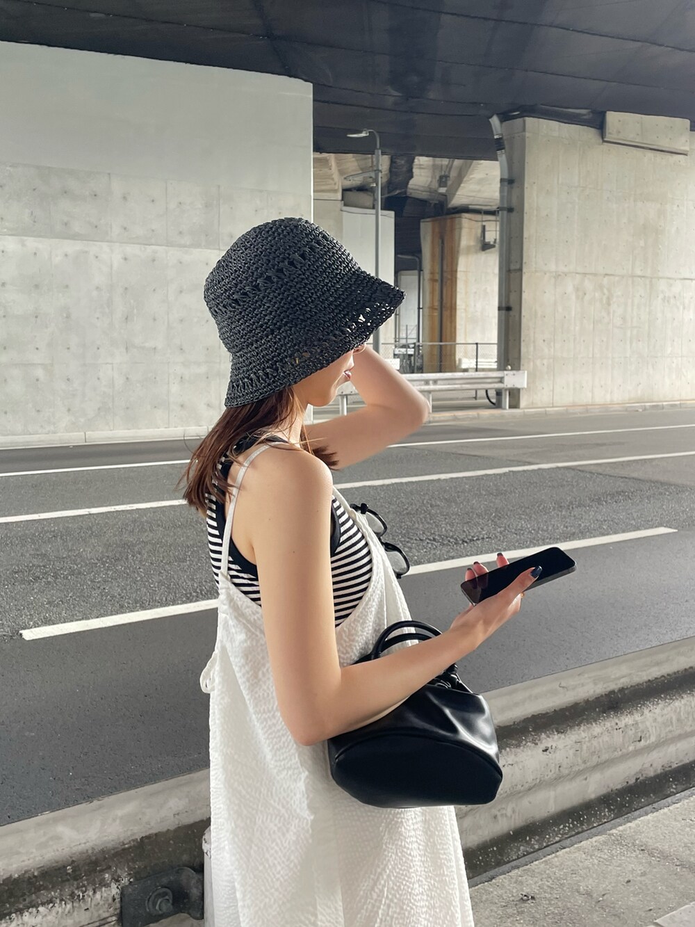 ホワイト系のタンクトップ、ホワイト系のワンピース、ブラック系のハンドバッグを着用したレディースの夏コーディネートの4枚目の写真