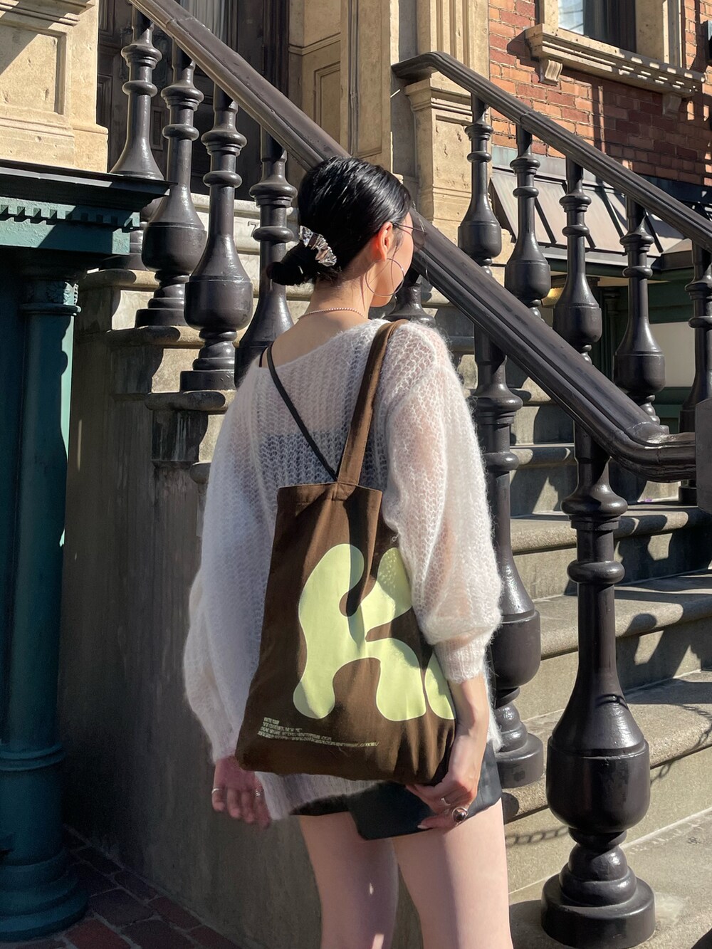 ホワイト系のニット/セーター、ブラック系のショルダーバッグ、グレー系のサングラスを着用したレディースの秋コーディネートの5枚目の写真