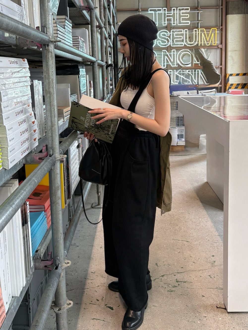 ブラック系のショルダーバッグ、ブラック系のブーツ、ブラック系のニットキャップ/ビーニーを着用したレディースの春コーディネートの4枚目の写真