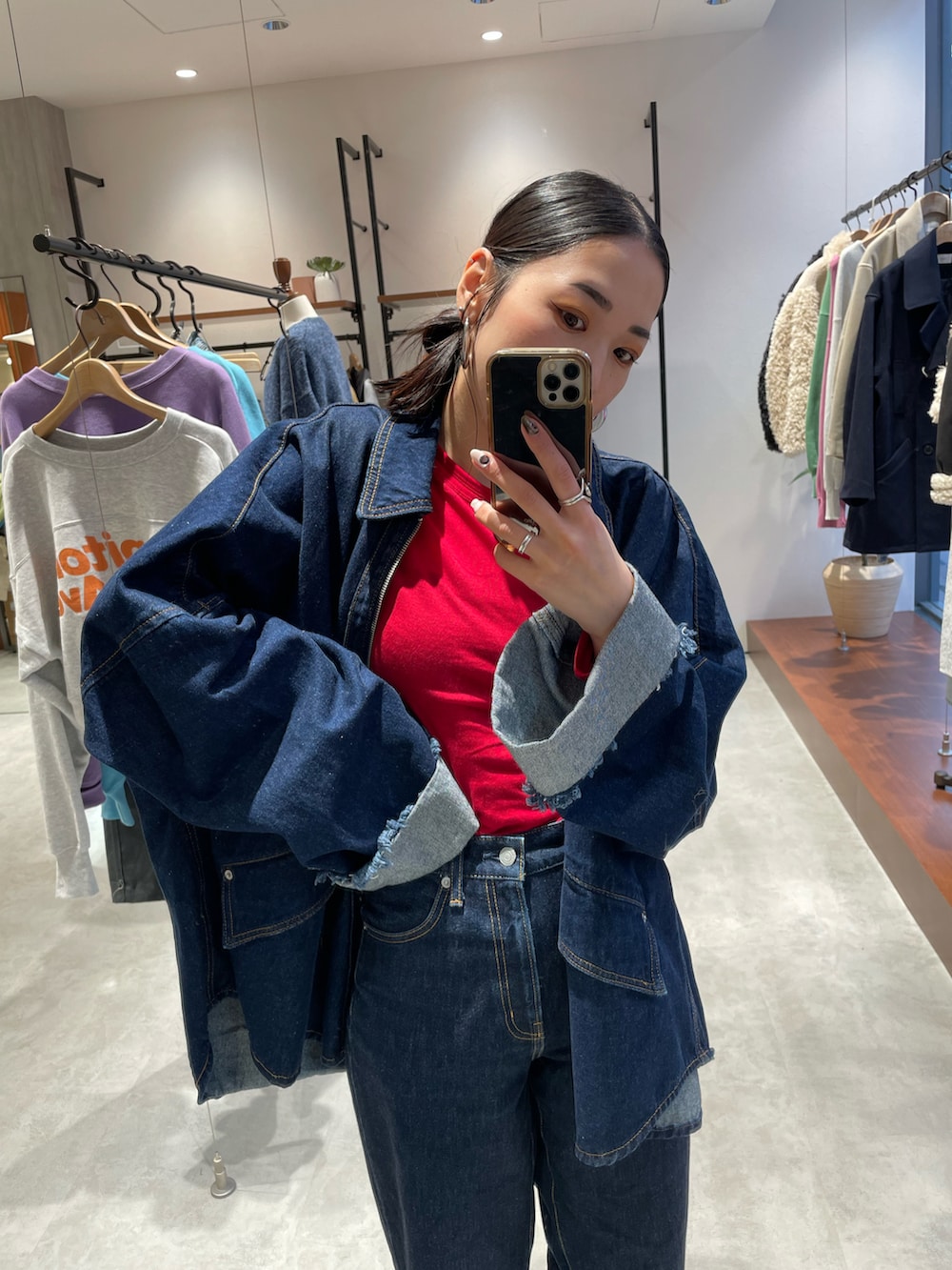 ブルー系のデニムパンツ、ベージュ系のスニーカー、ブルー系のデニムジャケットを着用したレディースの秋コーディネートの5枚目の写真