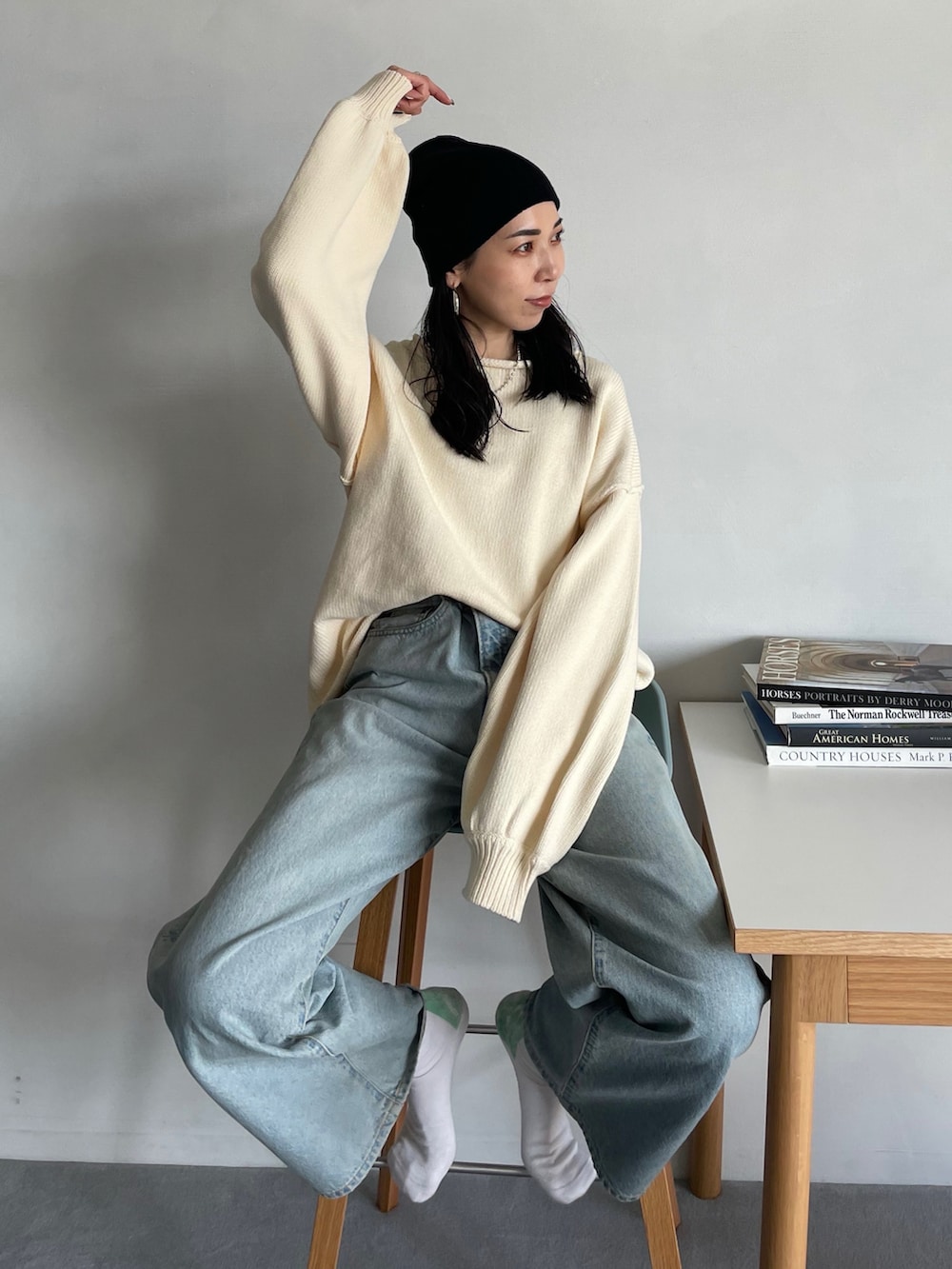 ホワイト系のニット/セーター、ブルー系のデニムパンツ、ブラック系のニットキャップ/ビーニーを着用したレディースの秋コーディネートの2枚目の写真