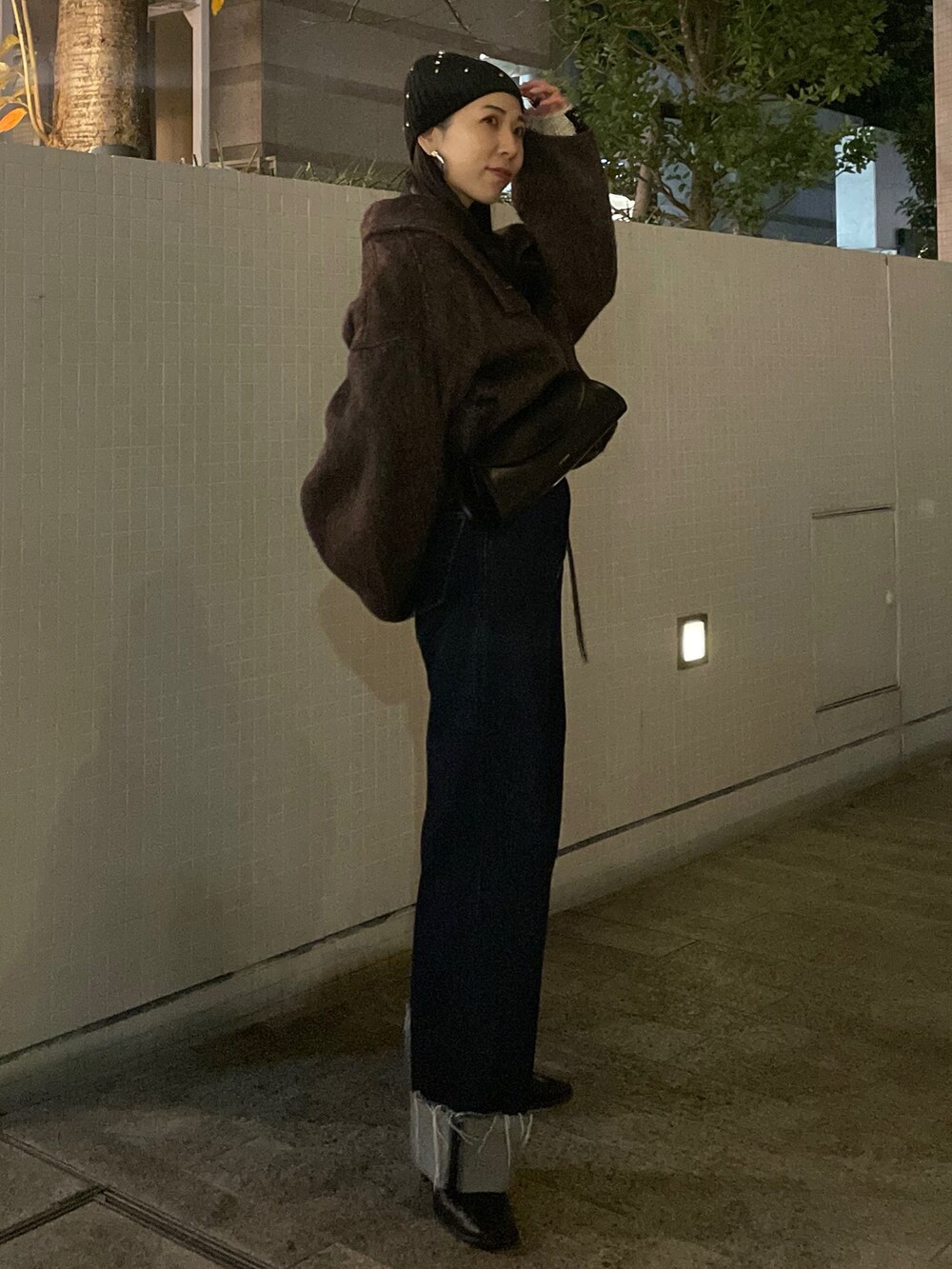 ブルー系のデニムパンツ、ブラウン系のその他アウター、ホワイト系のニット/セーターを着用したレディースの冬コーディネートの2枚目の写真