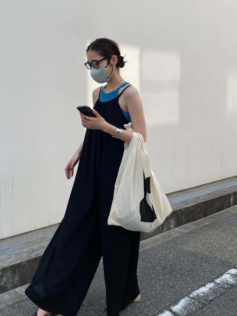 ブラック系のオールインワン・サロペット、ブルー系のタンクトップ、ブラック系のサンダルを着用したレディースの春コーディネートの5枚目の写真