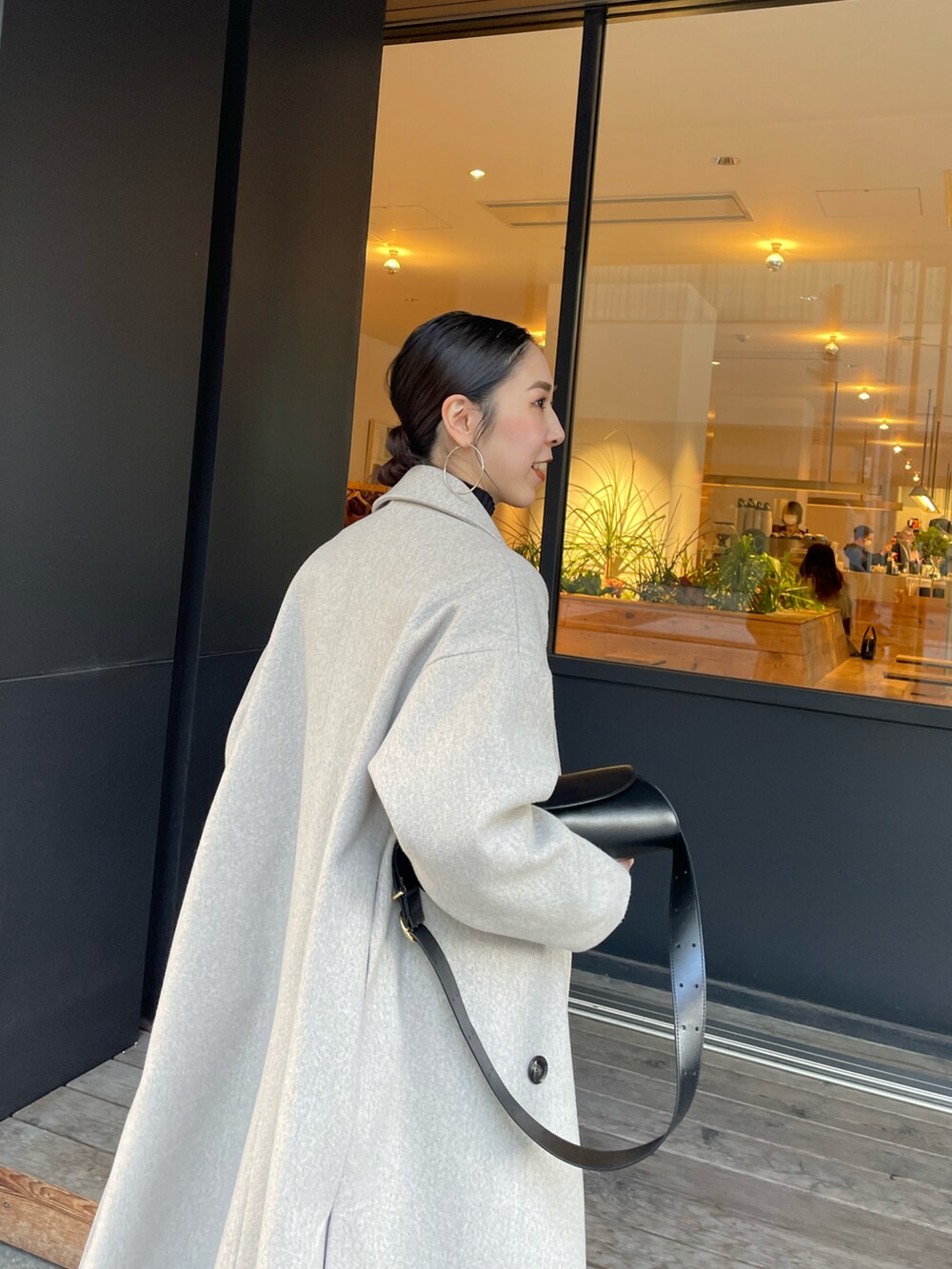 ブラック系のショルダーバッグ、ブラック系のブーツ、ブラック系のニット/セーターを着用したレディースの冬コーディネートの4枚目の写真