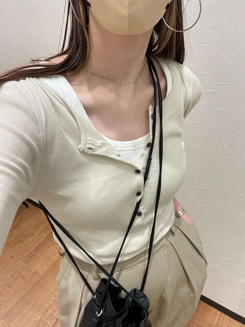 ベージュ系のTシャツ/カットソー、ベージュ系のスラックス、ブラック系のショルダーバッグを着用したレディースの夏コーディネートの4枚目の写真