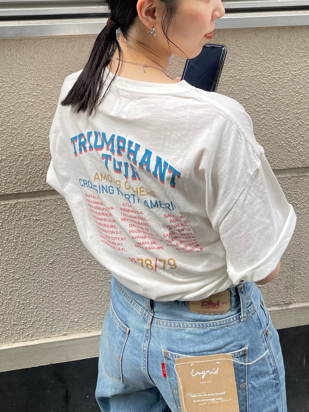 ブルー系のデニムパンツ、ホワイト系のスニーカー、ホワイト系のTシャツ/カットソーを着用したレディースの春コーディネートの5枚目の写真