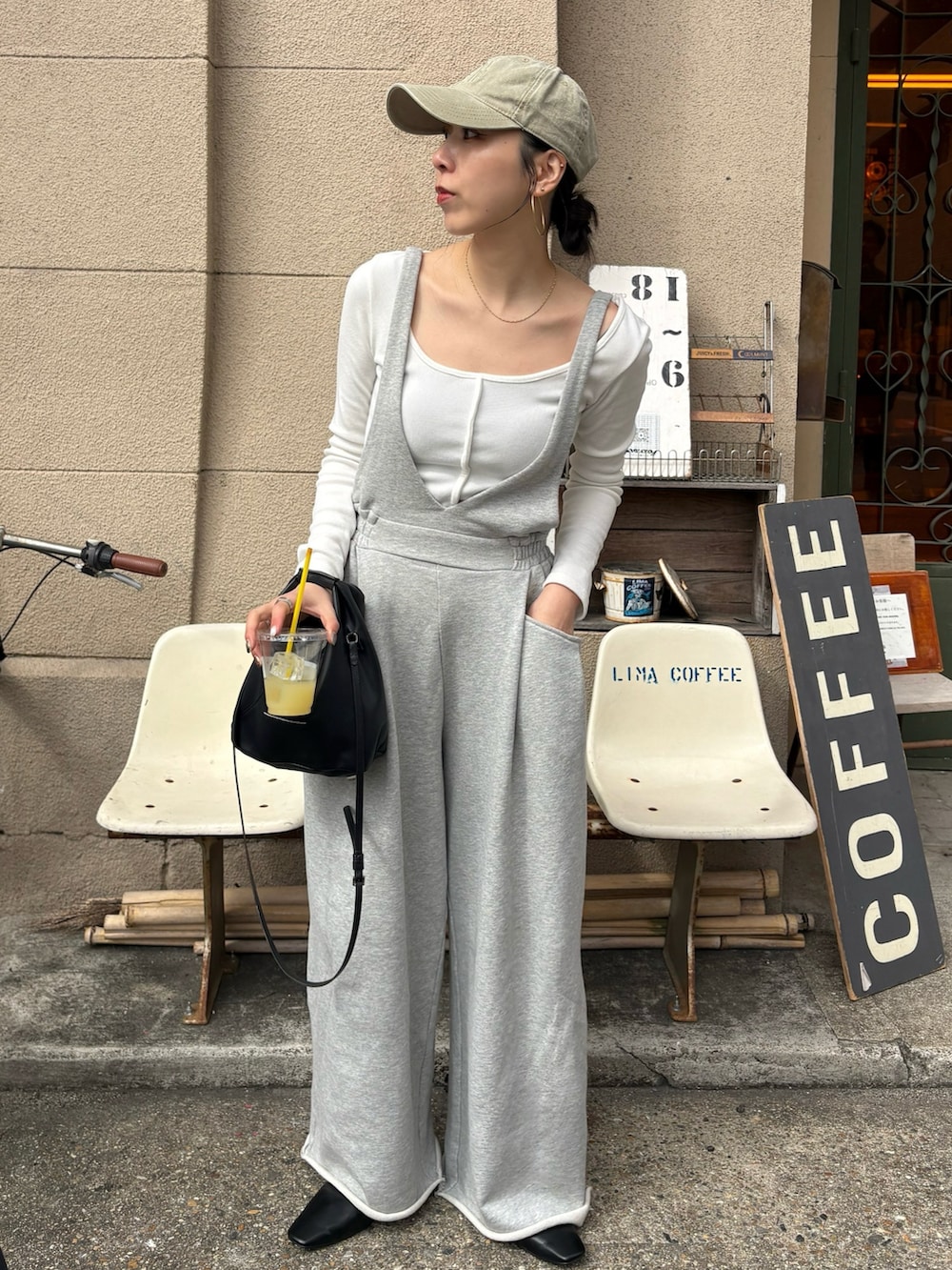 ブラック系のショルダーバッグ、ブラック系のサンダル、シルバー系のネックレスを着用したレディースの春コーディネートの2枚目の写真